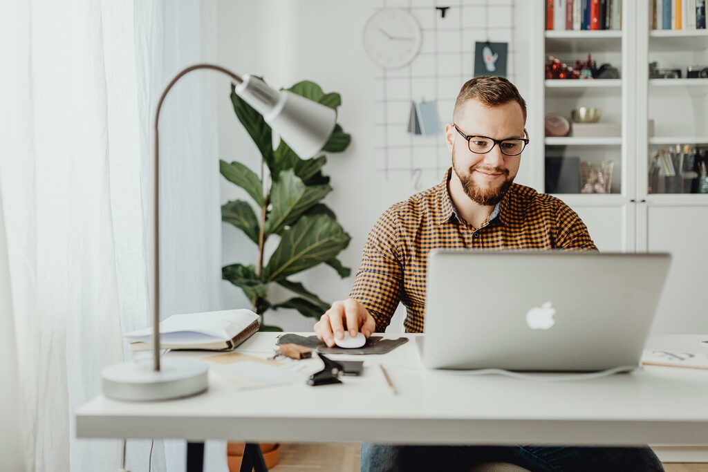 A person happily working on a laptop, engaged in their daily MongoDB tasks.