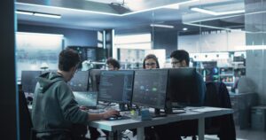 Developers collaborating at their workstations on a MongoDB project during a team planning session.