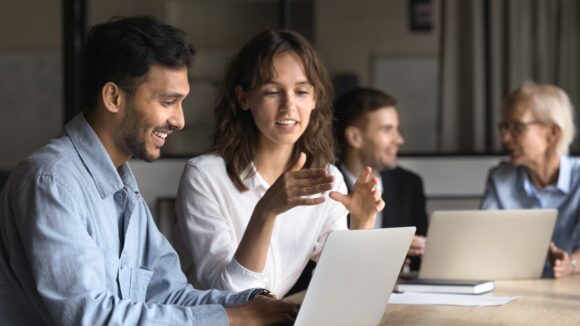 Two support engineers collaborating at a workstation to troubleshoot MongoDB issues.